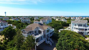 A coastal residential area with multiple two-story houses featuring balconies and large windows.