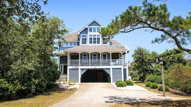 A large two-story house with a front porch, a garage, and a well-maintained lawn. - Oceanside, Private Pool, Volleyball, Screened porch, PI61, Without a Porpoise (Corolla)