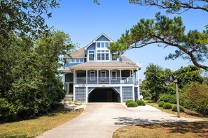 A large two-story house with a front porch, a garage, and a well-maintained lawn.