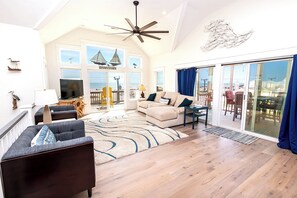 A spacious living room with a large sofa, a television, and a ceiling fan. - Semi-Oceanfront, Wild Horses, Hot Tub, Ocean Views! 4x2000, Sandfiddler Inn (Corolla)
