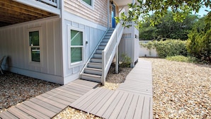 A two-story house with a wooden deck, a front porch, and a staircase leading to the second floor. - Oceanside, Private Pool, Walking distance to town of Duck, Foosball, T3, Bella Vita (Duck)