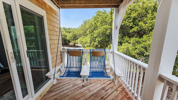 A wooden deck with a swing chair and a sliding glass door. - Oceanside, Private Pool, Walking distance to town of Duck, Foosball, T3, Bella Vita (Duck)