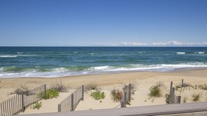 A beach with a wooden fence and sparse vegetation.