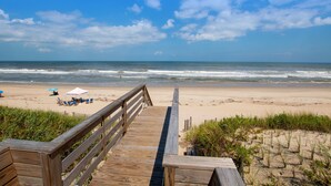 A wooden boardwalk leading to a beach with umbrellas and lounge chairs. - OCEANFRONT, Ocean views, beach access, Pool, PI139, Pine Haven (Corolla)