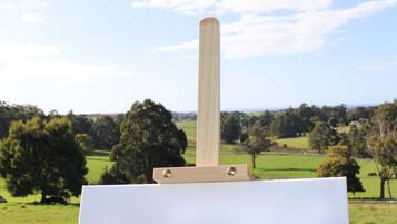 A blank easel with a wooden handle in a landscape setting.