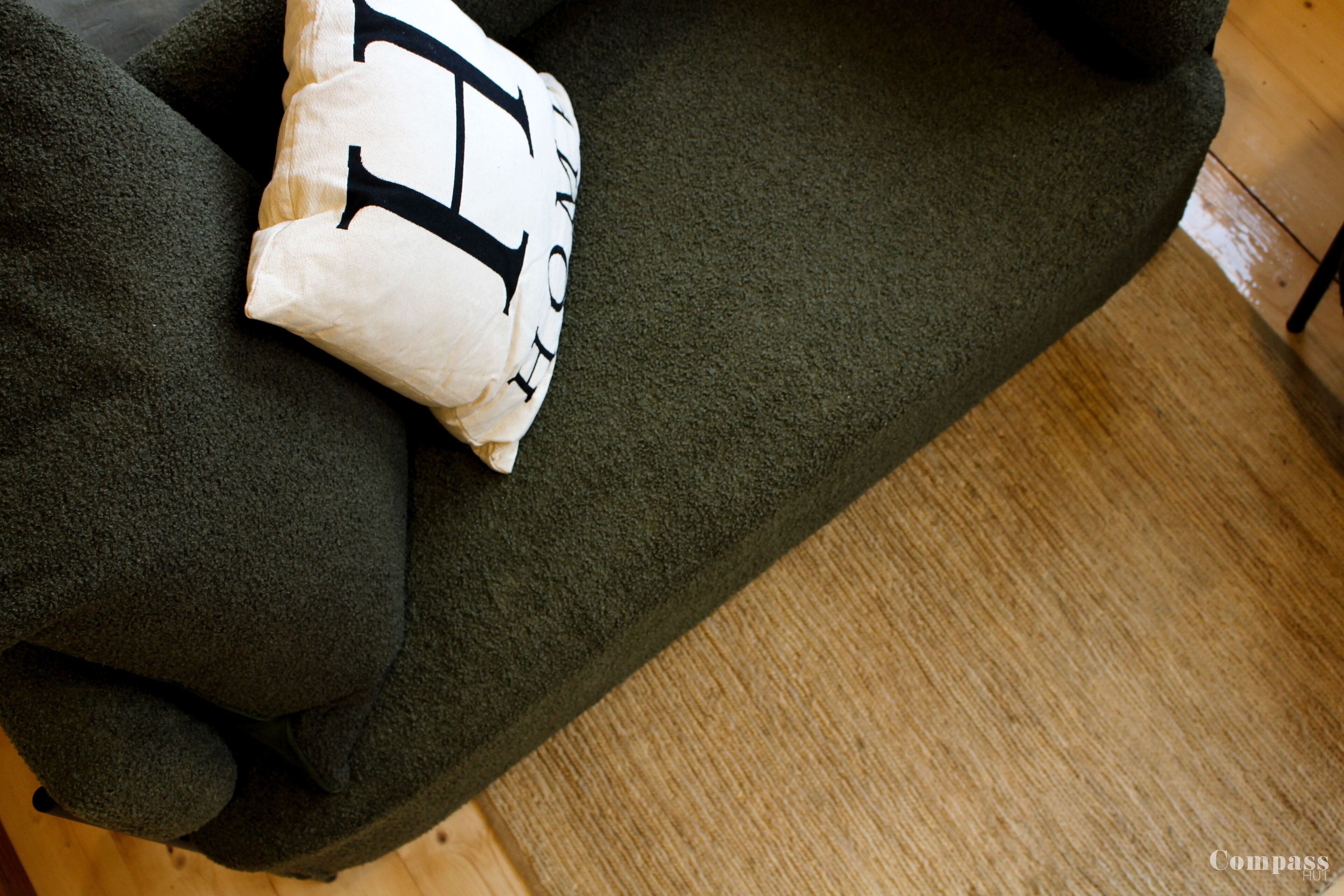 A dark green sofa with a white cushion featuring black text.