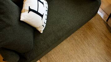 A dark green sofa with a white cushion featuring black text.