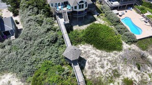 Et stort hus med en terrasse, swimmingpool og et overdækket udeområde.