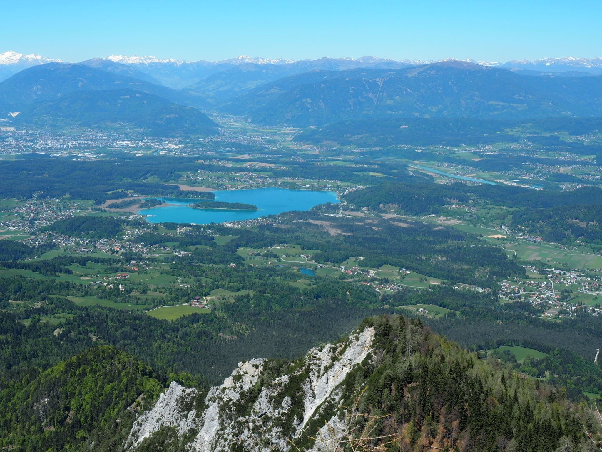 Un paisaje montañoso con un lago y pequeñas poblaciones dispersas.
