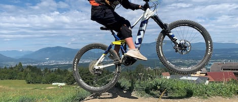Una persona montando una bicicleta de montaña realizando un salto.