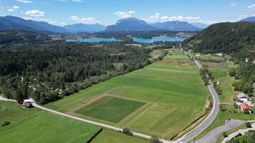 Paesaggio rurale con una strada, campi e un lago.