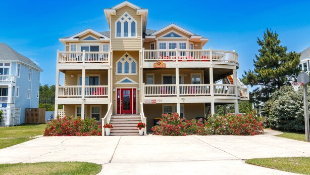 A two-story building with a red door, balconies, and a sign that reads "Suite EA". - Oceanside, 8 BRs, Private Pool and Hot Tub, Pool Table, PI109, Sweet TEA (Corolla)