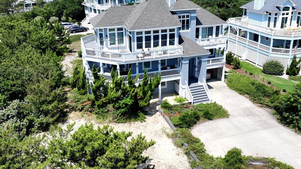 A large, multi-story house with multiple balconies and a spacious driveway. - Semi-Oceanfront, Private Pool with big pool deck, Close to Beach, PI12, A Shore Thing (Corolla)