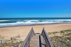 A wooden boardwalk leading to a beach with waves, clear sky, and sandy shore. - OCEANFRONT, Ocean Views, ELEVATOR, Private Beach Walkway, BB14, Heart Of Duck (Duck)