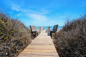 A wooden boardwalk leading to beach chairs on a clear day. - OCEANFRONT, Ocean Views, ELEV, Pool, Pool Table, Priv Beach Access, PI187, Right On The Beach (Corolla)