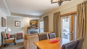 Una habitación de hotel con una mesa de comedor, sofá y chimenea.