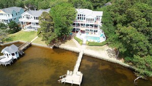 Un'ampia casa con numerosi balconi e un molo che si protende sull'acqua.