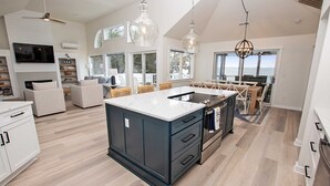 Una cocina amplia con una isla grande, electrodomésticos modernos y vistas al exterior.