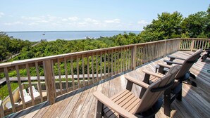 Une terrasse en bois avec des sièges extérieurs et une vue sur la mer.