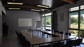 A conference room with a long table, chairs, a whiteboard, and large windows. - Henri 4 (Rostrenen)