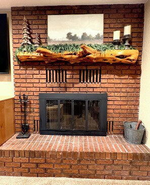A fireplace with a rustic log design, a mantel with candles, and a framed picture above. - 1BD Ski-in/Ski-out Condo Near Lift 8 & 1. Grab a Lift and Ski To Either Lodge. (Brian Head)