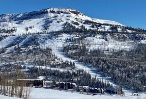 A snow-covered mountain with a ski slope and buildings at the base. - 1BD Ski-in/Ski-out Condo Near Lift 8 & 1. Grab a Lift and Ski To Either Lodge. (Brian Head)