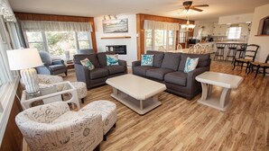 A spacious living room with a sofa set, a coffee table, and a dining area with chairs and a table. - Oceanside, 400 ft to Beach access, screened porch, SNH416, Ocean Adventure (Nags Head)