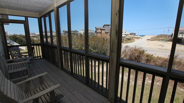 A wooden deck with a view of a beach and houses. - Oceanside, 400 ft to Beach access, screened porch, SNH416, Ocean Adventure (Nags Head)