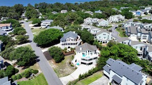 A residential area with houses, roads, and a body of water in the background.