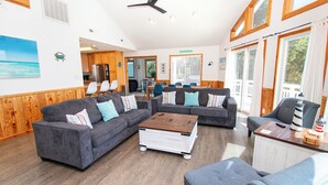 A spacious living area with multiple sofas, a coffee table, and a dining table.