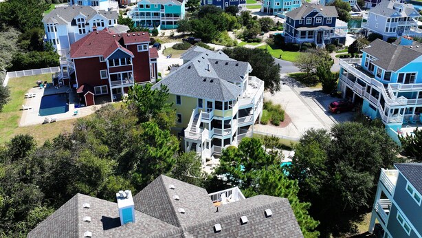 A coastal residential area with houses featuring balconies and a swimming pool. - Oceanside, Private Pool, Hot Tub, Buck Island Amenities, BU21, Island Girl (Corolla)