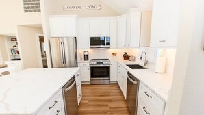 A modern kitchen with white cabinetry, stainless steel appliances, and a marble countertop. - Oceanside, Private Pool, Hot Tub, Buck Island Amenities, BU21, Island Girl (Corolla)