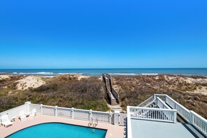 Una piscina con vista a la playa y al océano.
