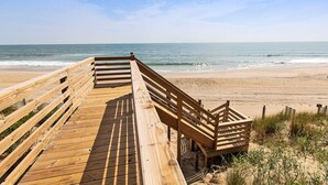 A wooden boardwalk leading to a sandy beach with the ocean in the background. - OCEANFRONT, 9 BRs, Private Pool, Theater Rm, Rec Rm, Ocean Views, PI134, Heavenly Dayz (Corolla)