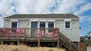 A two-story house with a wooden deck and a staircase leading to the second floor. - OCEANFRONT, Ocean Views, Sun Deck, KH121, Pirate Queen (Kitty Hawk)