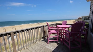 A wooden deck with pink chairs and a table overlooking a beach. - OCEANFRONT, Ocean Views, Sun Deck, KH121, Pirate Queen (Kitty Hawk)