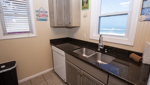A kitchen with a double sink, a dishwasher, and a window with a view of the ocean. - OCEANFRONT, Ocean Views, Sun Deck, KH121, Pirate Queen (Kitty Hawk)