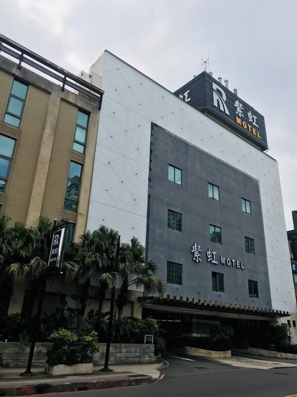 A modern building with a sign that reads "Motel" and "Motel" in another language. - Purple Rainbow Motel (New Taipei City)