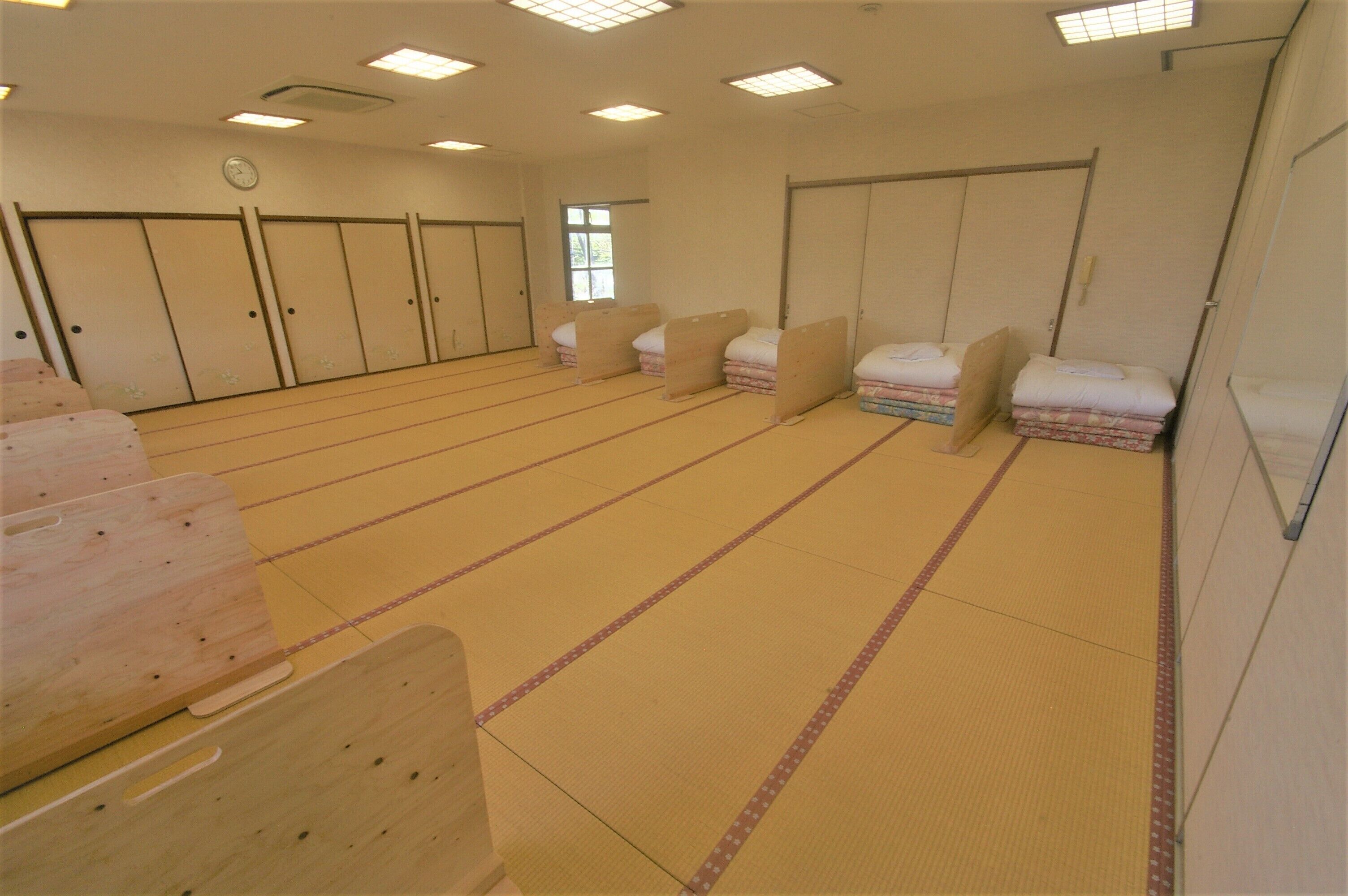 A room with tatami mats, wooden benches, and sliding doors.