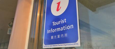 A sign with the text "Tourist Information" and a symbol indicating a tourist information center.
