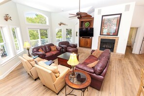 A spacious living room with leather sofas, a fireplace, and a television. - Soundfront, Dog Friendly, Private Pool, Rec Room, 549, Sunrise Sunset (Corolla)