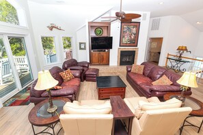 A spacious living room with leather sofas, a coffee table, and a fireplace. - Soundfront, Dog Friendly, Private Pool, Rec Room, 549, Sunrise Sunset (Corolla)