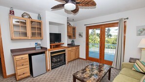 A compact kitchen with a built-in refrigerator, wooden cabinets, and a television. - Oceanside, Comm Amenities, Priv Pool, Close to Beach, Rec Rm, 219, Turtle Cove (Corolla)