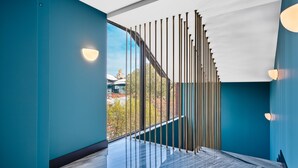 Een modern interieur met teal muren, een marmeren vloer en uitzicht door een glazen wand.