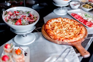 A variety of food items including a pizza, a salad, and some appetizers on a table.