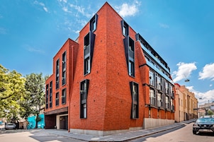 Un edificio moderno de ladrillo rojo con ventanas grandes y balcones.