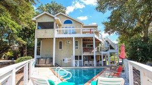 A two-story building with a pool and outdoor seating. - Soundfront, Private Pool, Hot Tub, Sound Views, Community Amenities, 345, Carolina Sunset (Corolla)