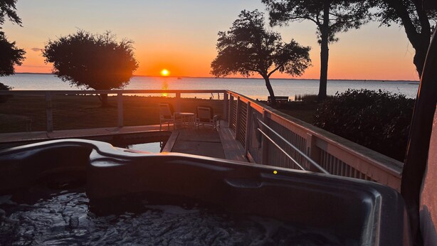A sunset view from a deck with chairs and a pool, overlooking a body of water. - Soundfront, Private Pool, Hot Tub, Sound Views, Community Amenities, 345, Carolina Sunset (Corolla)
