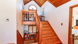 A wooden staircase leading to a loft bedroom with a skylight, a reading nook, and a view of the outdoors. - Soundfront, Private Pool, Hot Tub, Sound Views, Community Amenities, 345, Carolina Sunset (Corolla)
