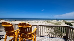 A wooden deck with two yellow Adirondack chairs facing a beach with dunes and the ocean. - OCEANFRONT, 4-wheel drive area, Wild Horses, Ocean Views! 4x1662, Dolphin Watch (Corolla)